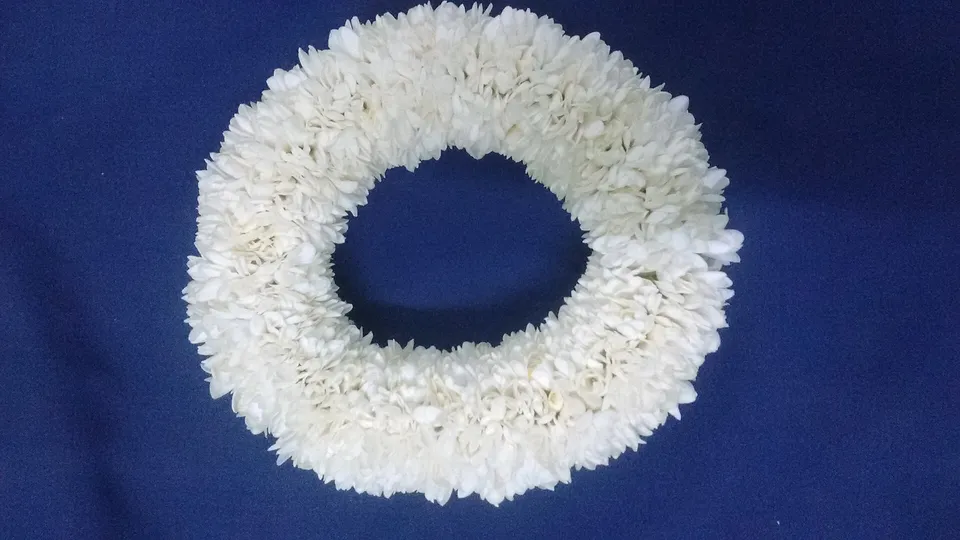 A thick ring of white jasmine flowers on a blue background