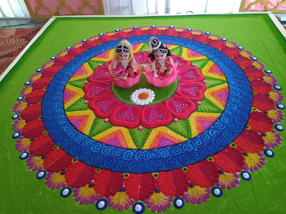 A large, colourful rangoli with a bride-and-groom motif at its centre
